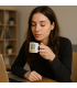 jeune femme boit son café dans une tasse personnalisée